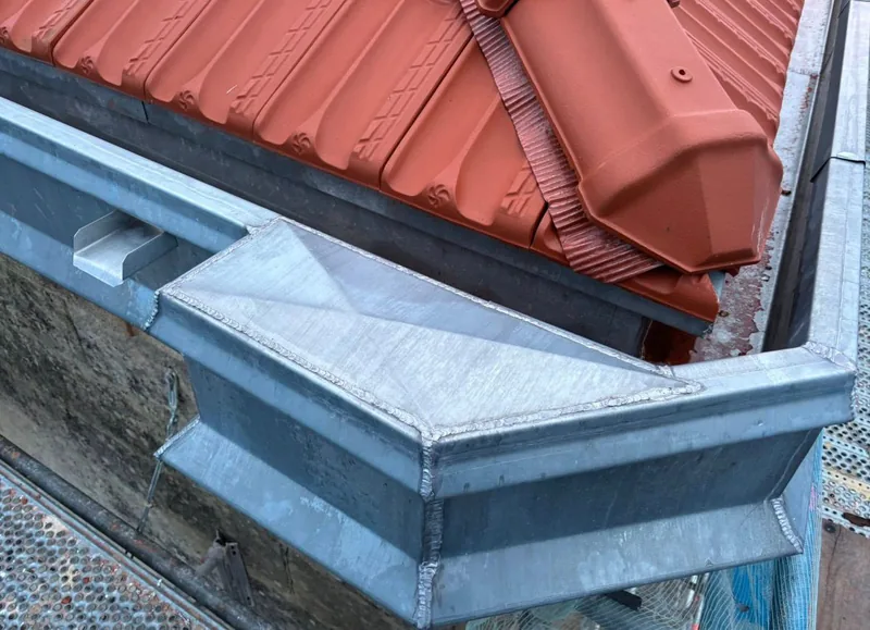 Chéneau et corniche en zinc neufs sur toiture en tuiles, à Sucy-en-Brie